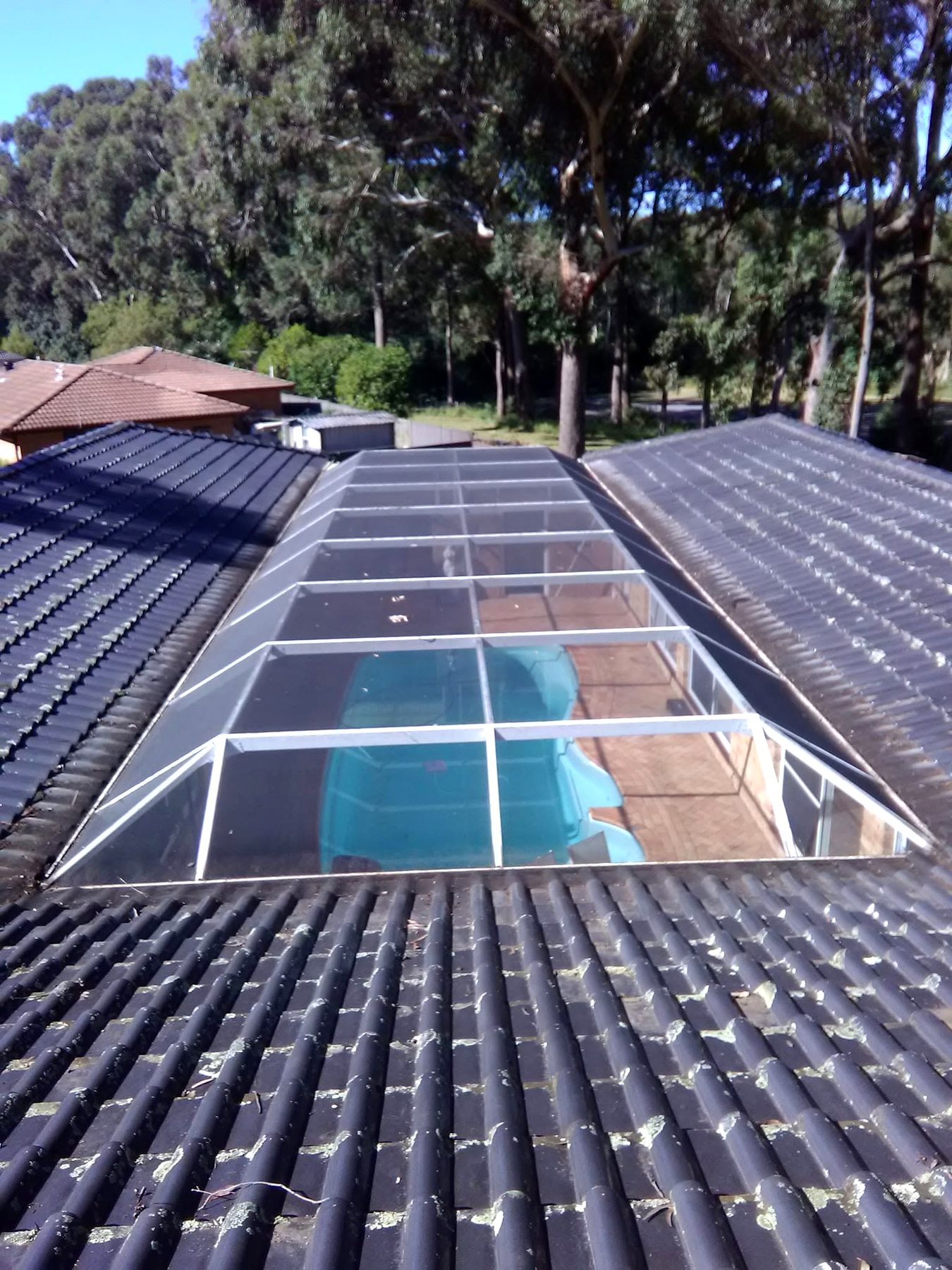 Roof and gutters beside a pool enclosure